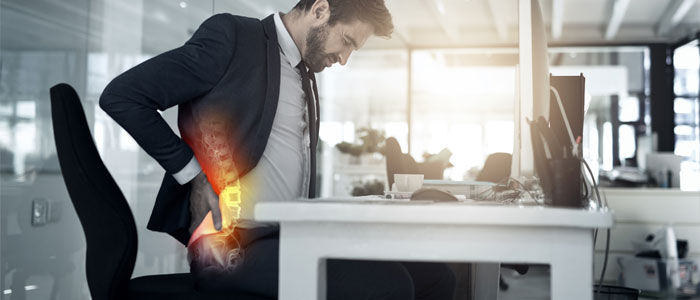 man at desk with back pain